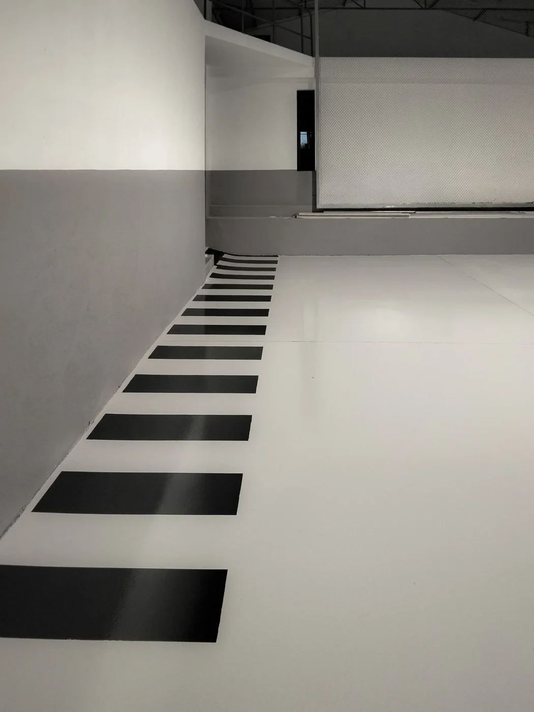 Pavimento epóxi branco com passadeira marcada a preto numa oficina