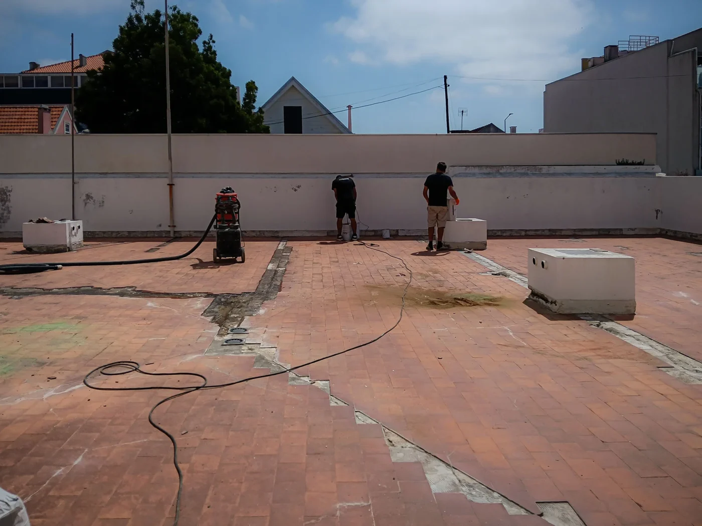 Equipa a preparar o suporte de um terraço com máquina de desbaste